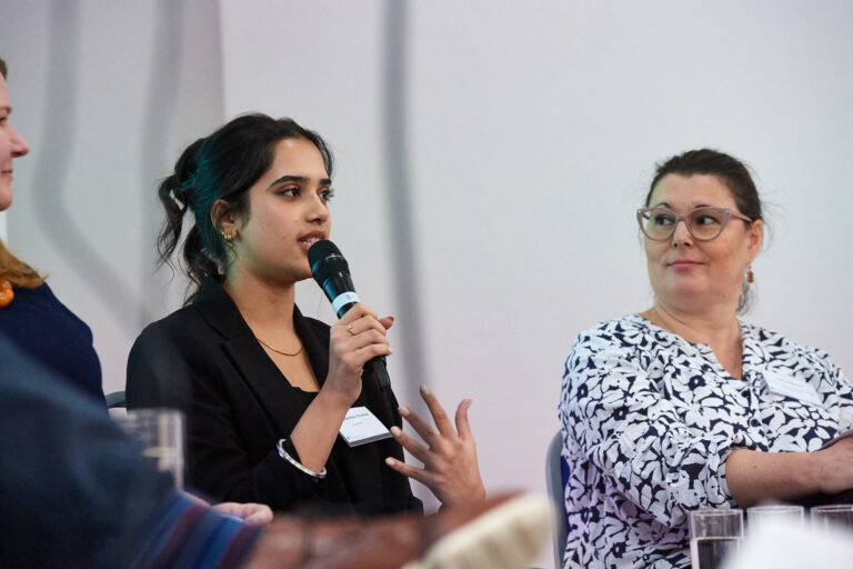 A panel member speaking into a microphone
